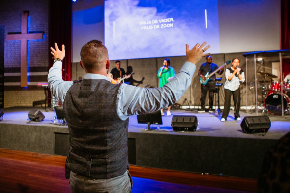 Spreker bidt voor de zaal