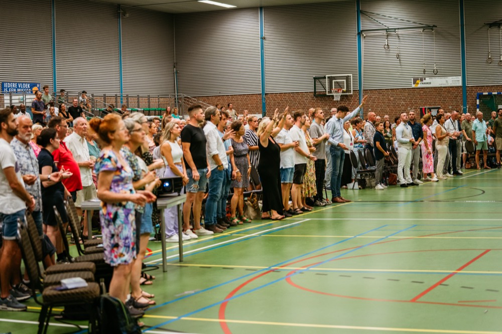 Volle zaal staat op tijdens de genezingsdienst